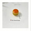 A small, round hamburger-shaped fidget slider toy with an orange bun and green lettuce visible on a white surface.