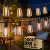 A string of solar powered LED bulbs hanging outdoors above a wooden deck.