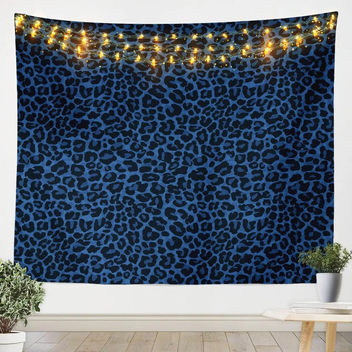 A dark blue leopard print tapestry wall hanging illuminated by warm string lights.