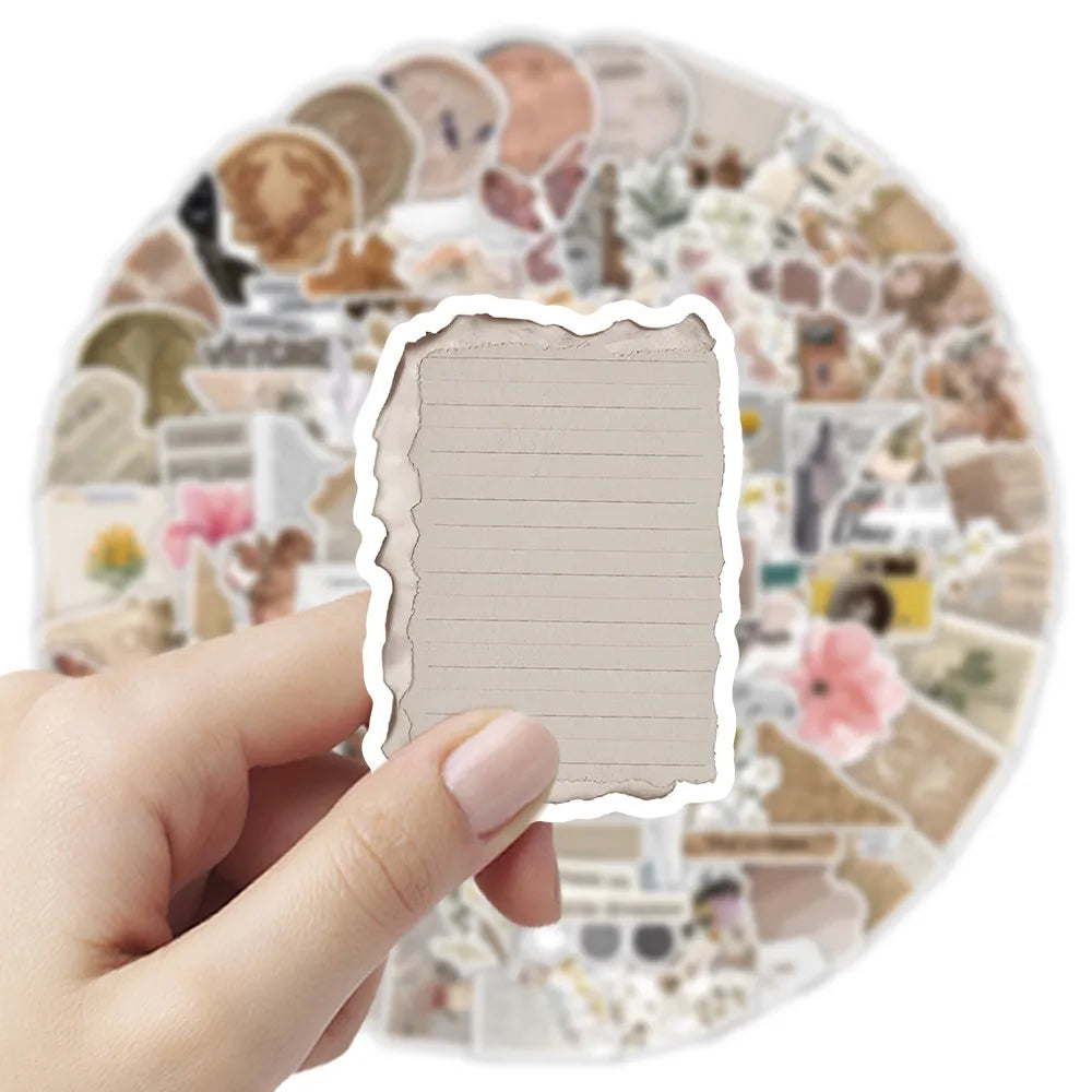 A hand holds a blank, lined page cutout from an incomplete diary style graffiti sticker sheet for decoration.