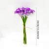 A bouquet of six artificial purple calla lilies with green stems shown against a white background.
