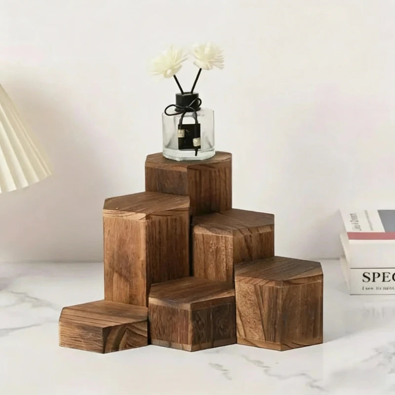 A wooden hexagonal display rack for jewelry and accessories holding a glass jar with white flowers.