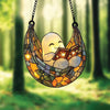 A hanging decoration shaped like a ghost reading an open book, made of stained glass.