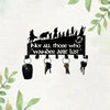 Black metal wall-mounted key holder with seven hooks silhouetted against a white background.