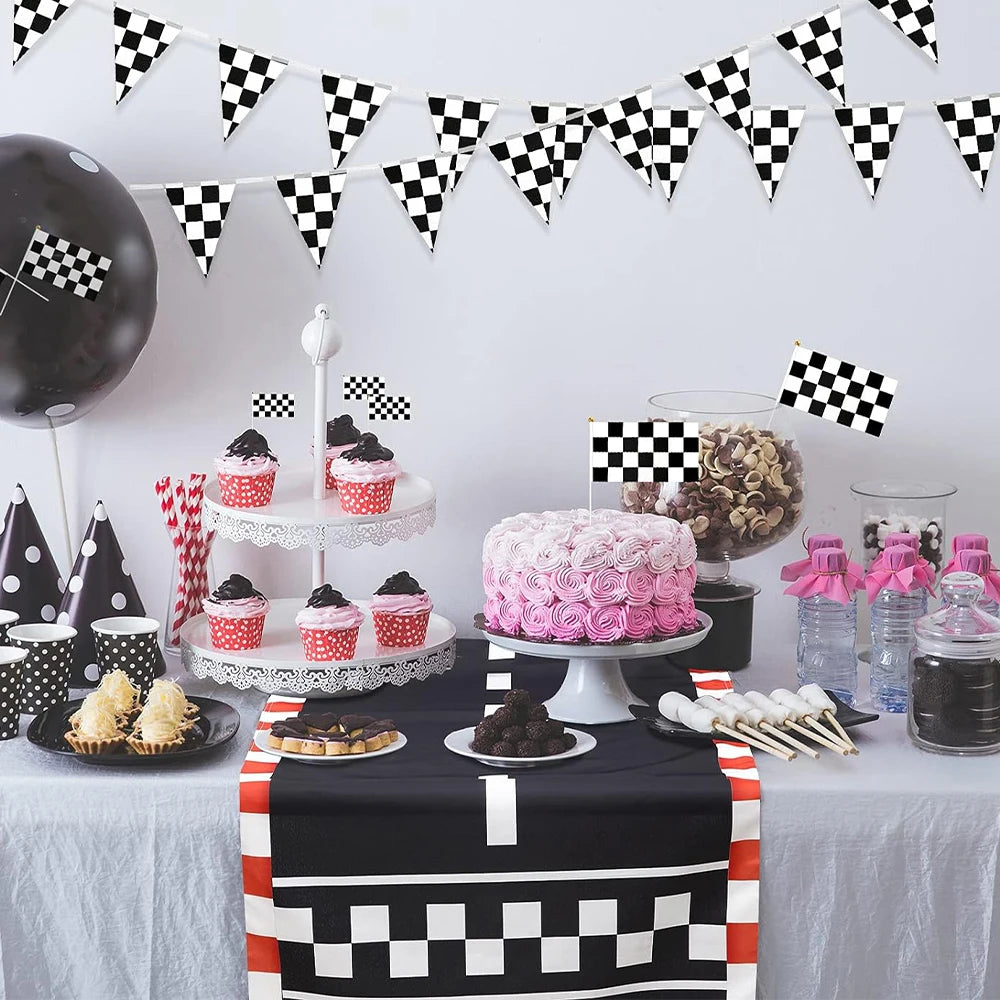 Une bannière de pavillon de course à carreaux suspendue sur un mur blanc au-dessus d'une table de dessert.