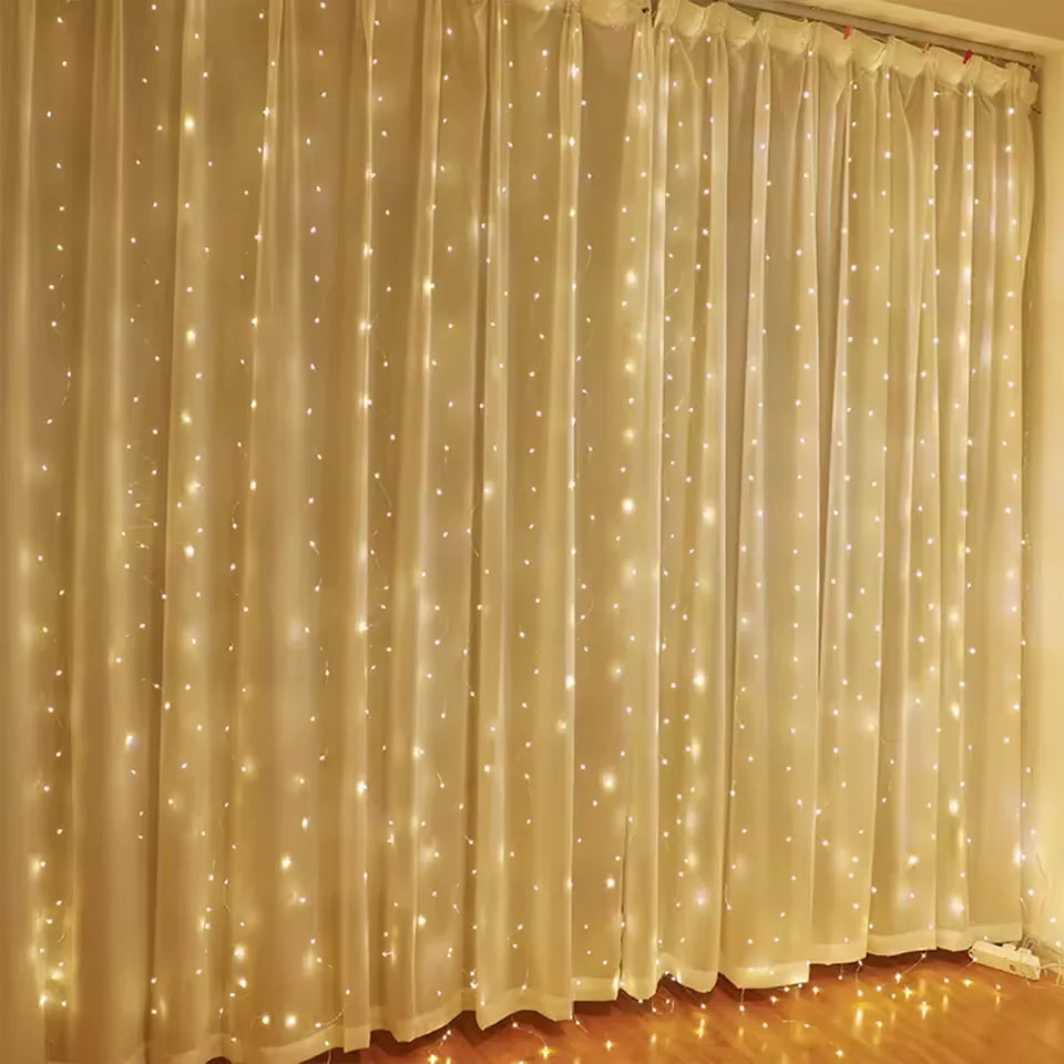 White sheer curtain illuminated by warm LED string lights creating a sparkling backdrop