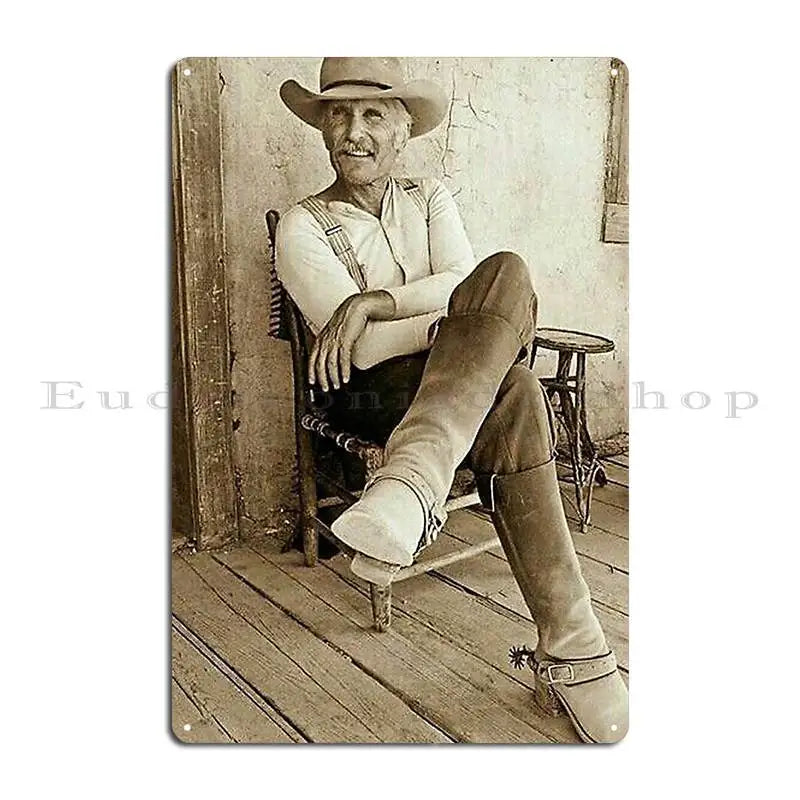 Sepia-toned photograph of an elderly man wearing a hat and sitting on a wooden chair.