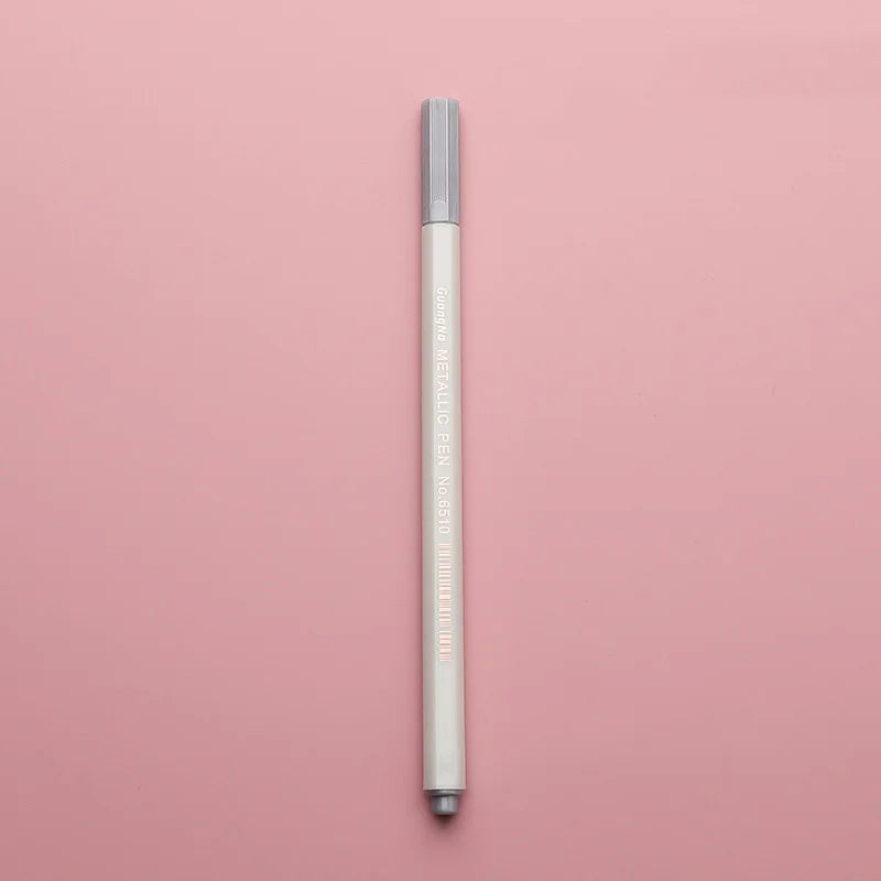 A silver transparent wax sealing bead pen standing vertically on a pink background.