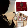 A hand-sewn silver prayer pocket decoration featuring a red fabric pouch and a cross design.