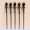 A set of four amethyst bee crystal scepters with gold accents and colored beads.