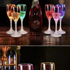Six verres à boire de couleur claire avec différents feux clignotants LED, disposés sur une surface en bois sombre.