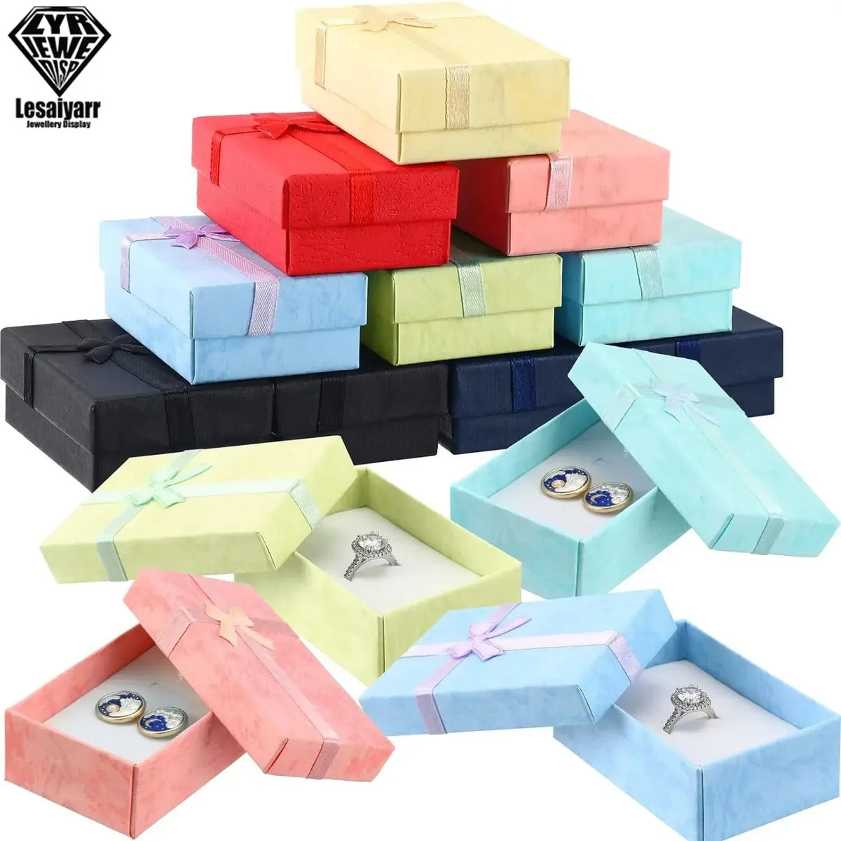 Una pila de cajas de regalo decorativas de joyería coloridas en rojo, rosa, azul y verde, con algunas abiertas mostrando anil
