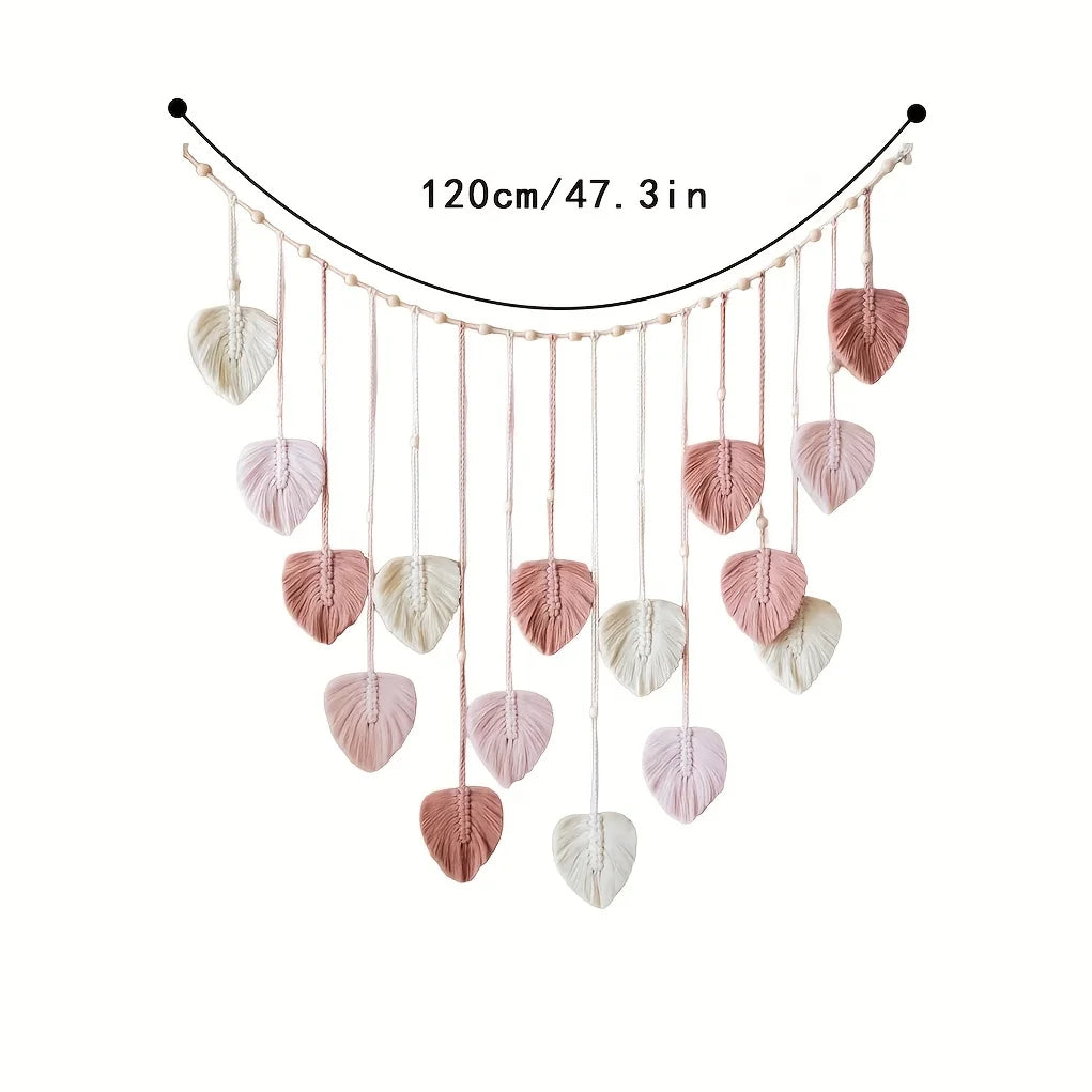 Handwoven pink leaf tassels hanging from a string, used as a decorative wall hanging.