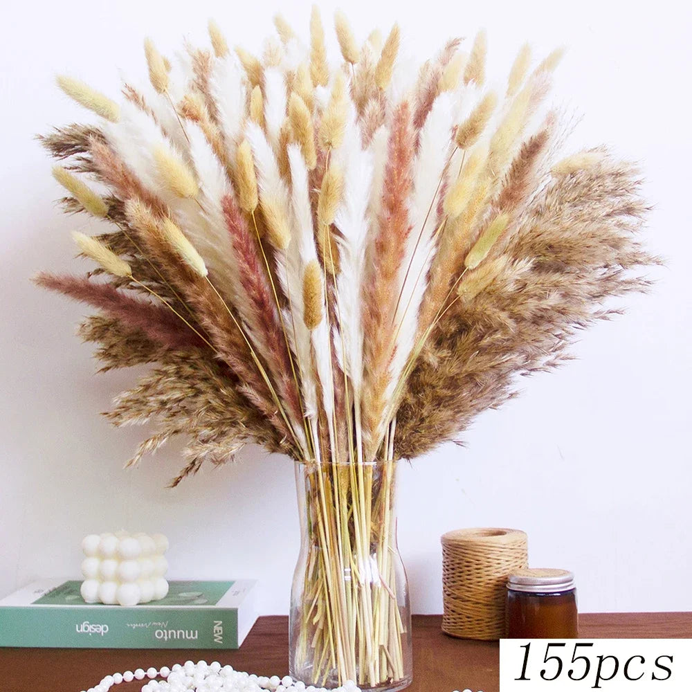Bouquet de queues de lapin de pampas séchées avec des plumes beige, marron et blanches dans un vase en verre