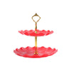A two-tier serving stand with a gold-colored metal frame and bright red, scalloped dishes for desserts or fruit.