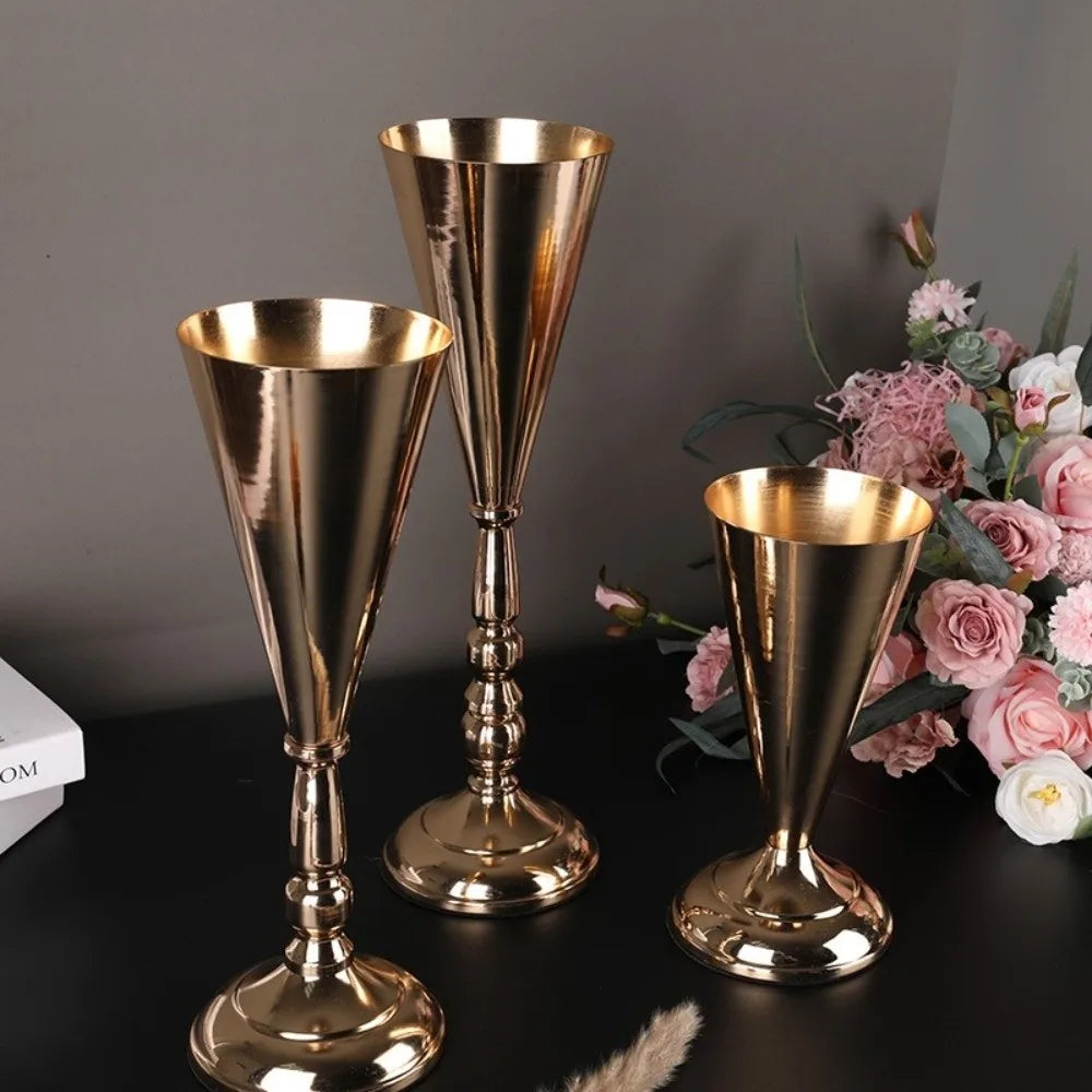A set of elegant golden silver wedding flower vases with tapered glass bowls and ornate bases.