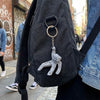 A collectible figurine set featuring Rocky and Grace, suspended by a gold-colored ring on a black backpack.