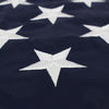 A close-up of a dark blue fabric featuring white embroidered stars in the pattern of an American flag.