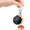 A hand is holding a black magic 8 ball keychain with an orange charm and a red ball.