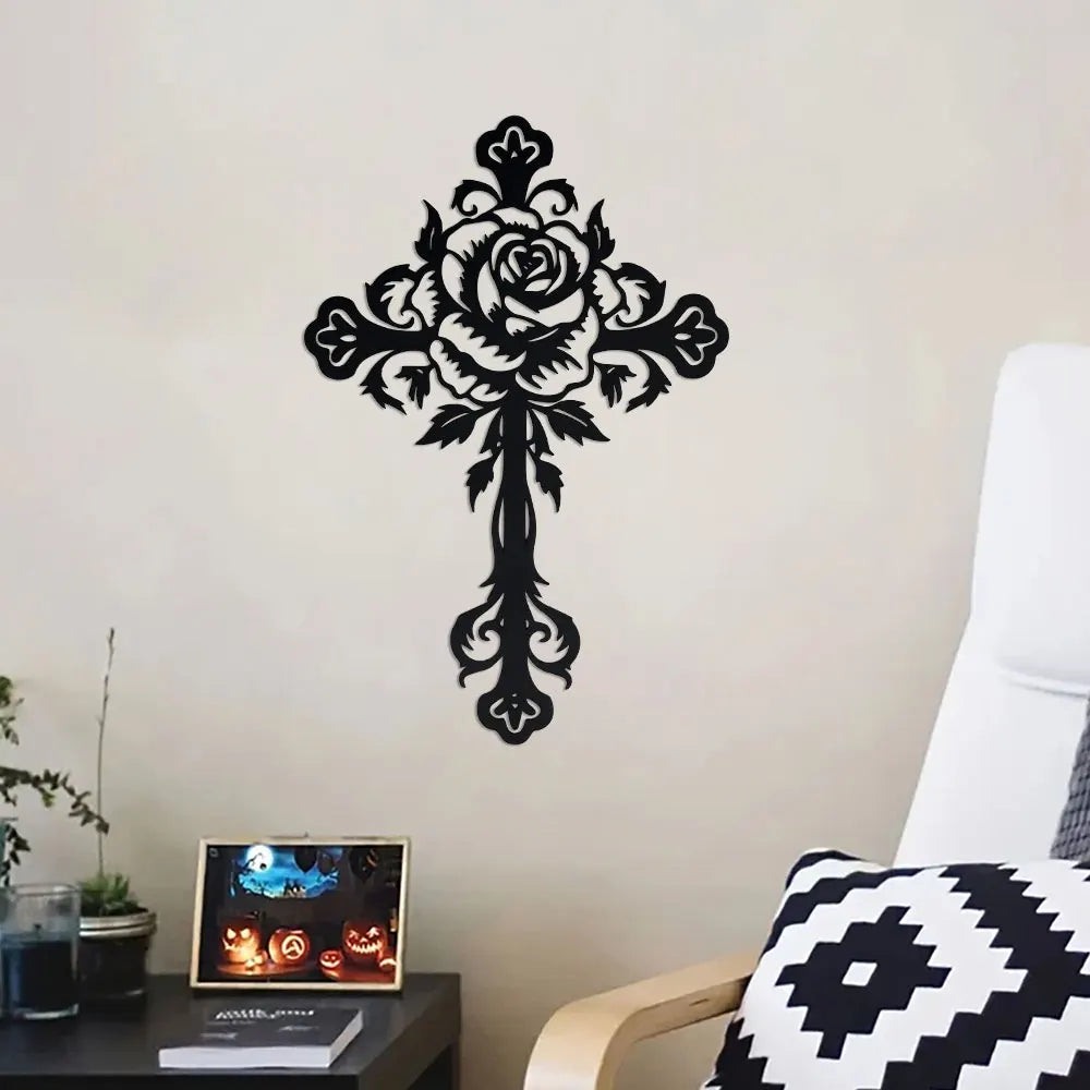 Black metal cross wall decor featuring an ornate rose design mounted on a white wall.