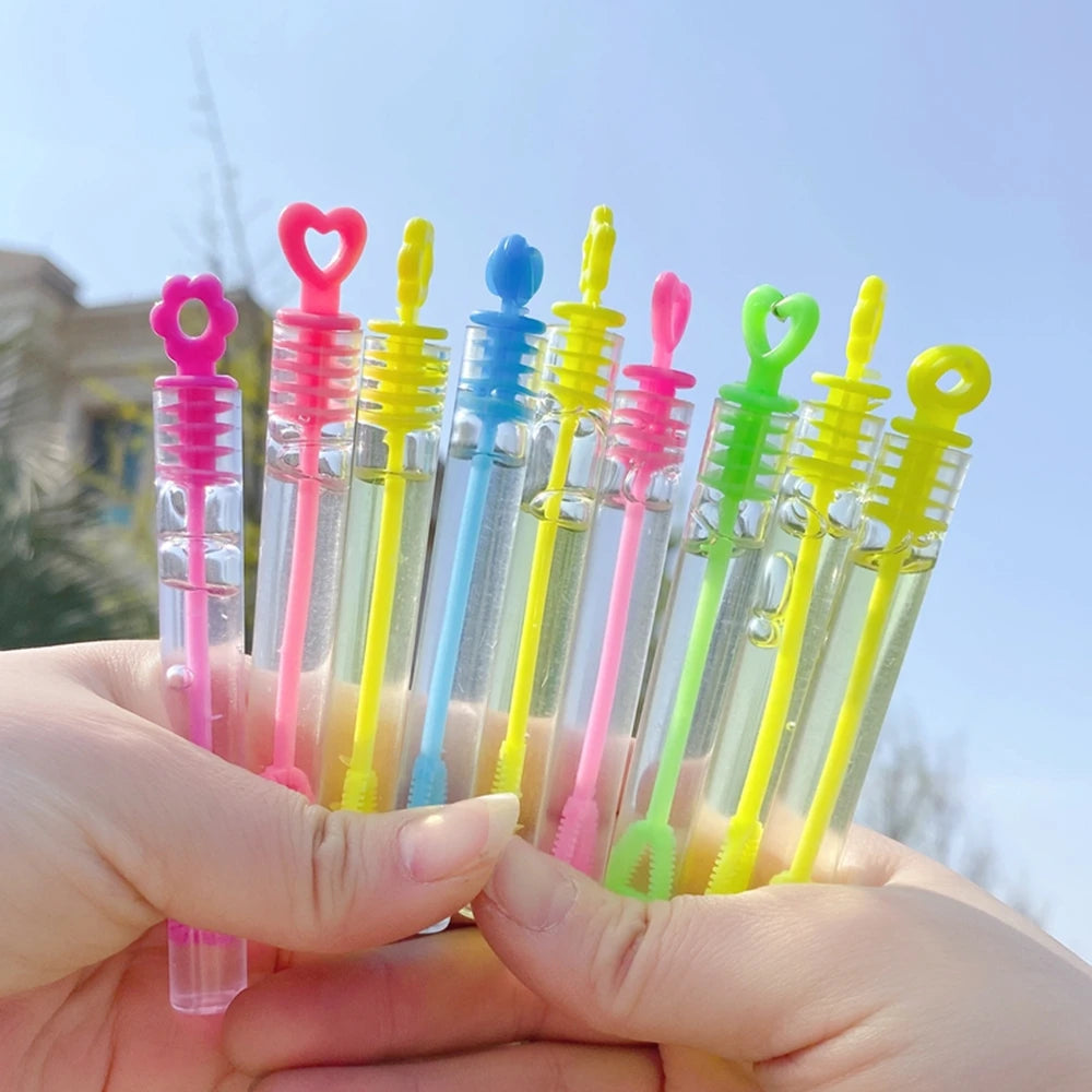 Une main tient une collection de mini tubes à bulles colorés pour des cadeaux de fête