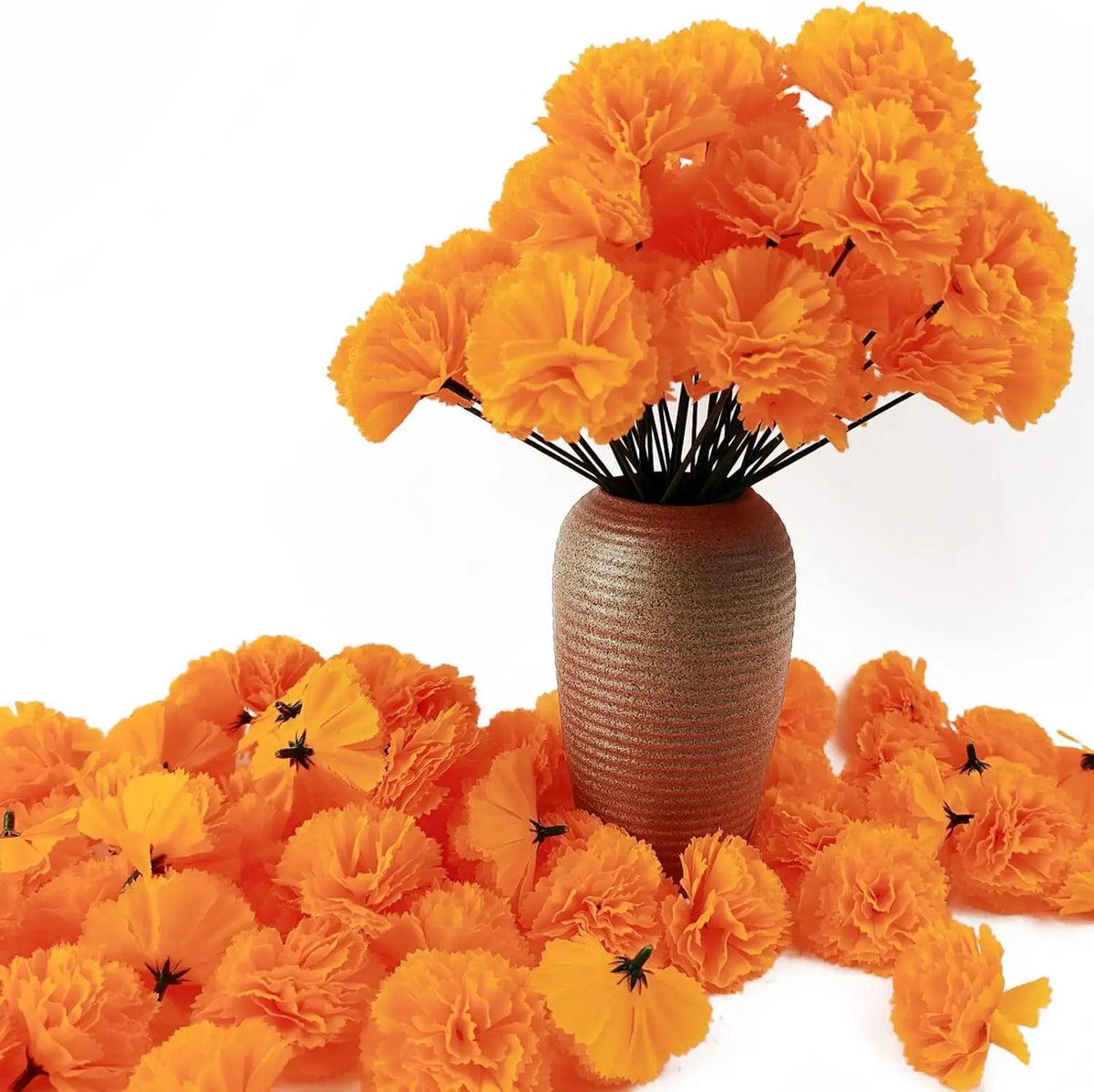 A bouquet of bright orange silk marigold flowers displayed in a textured vase.