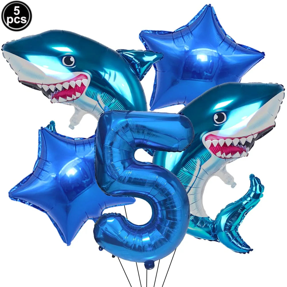 A set of blue shark foil balloons, including a number 5, for an ocean-themed party decoration.