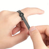 A hand is holding an adjustable ring sizer with a built-in magnifier, showing the scale and mechanism.
