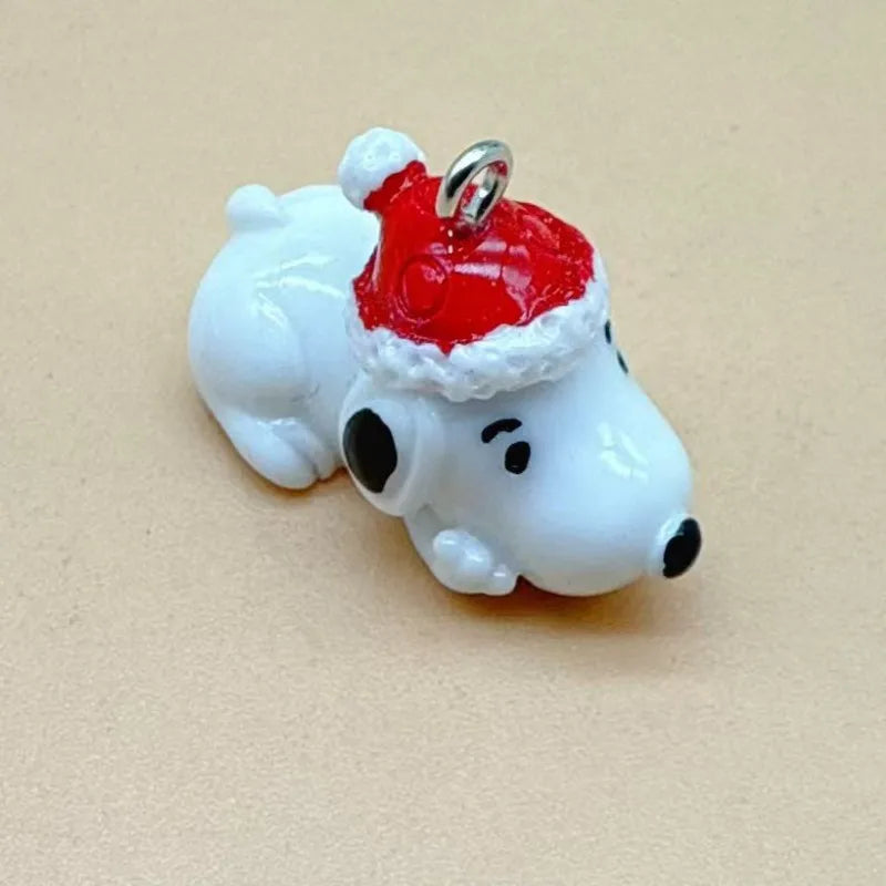 A white ceramic dog pendant with a red Santa hat and silver bail for jewelry making.