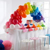 A white table balloon arch kit featuring colorful balloons arranged in an arc on a draped table.