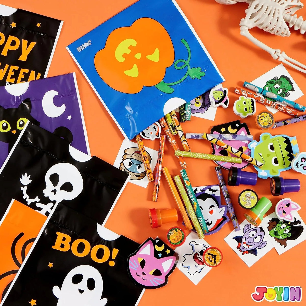 A collection of Halloween stationery including trick-or-treat bags, stickers, and themed paper crafts on an orange background