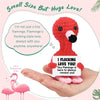 Eine Hand hält eine rote, aus Häkelarbeit gefertigte Flamingo-Puppe mit schwarzem Schnabel, umgeben von Text, der Liebe und U
