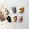 A set of mini puppy refrigerator magnets in various colors including white, gray, yellow, and pink.