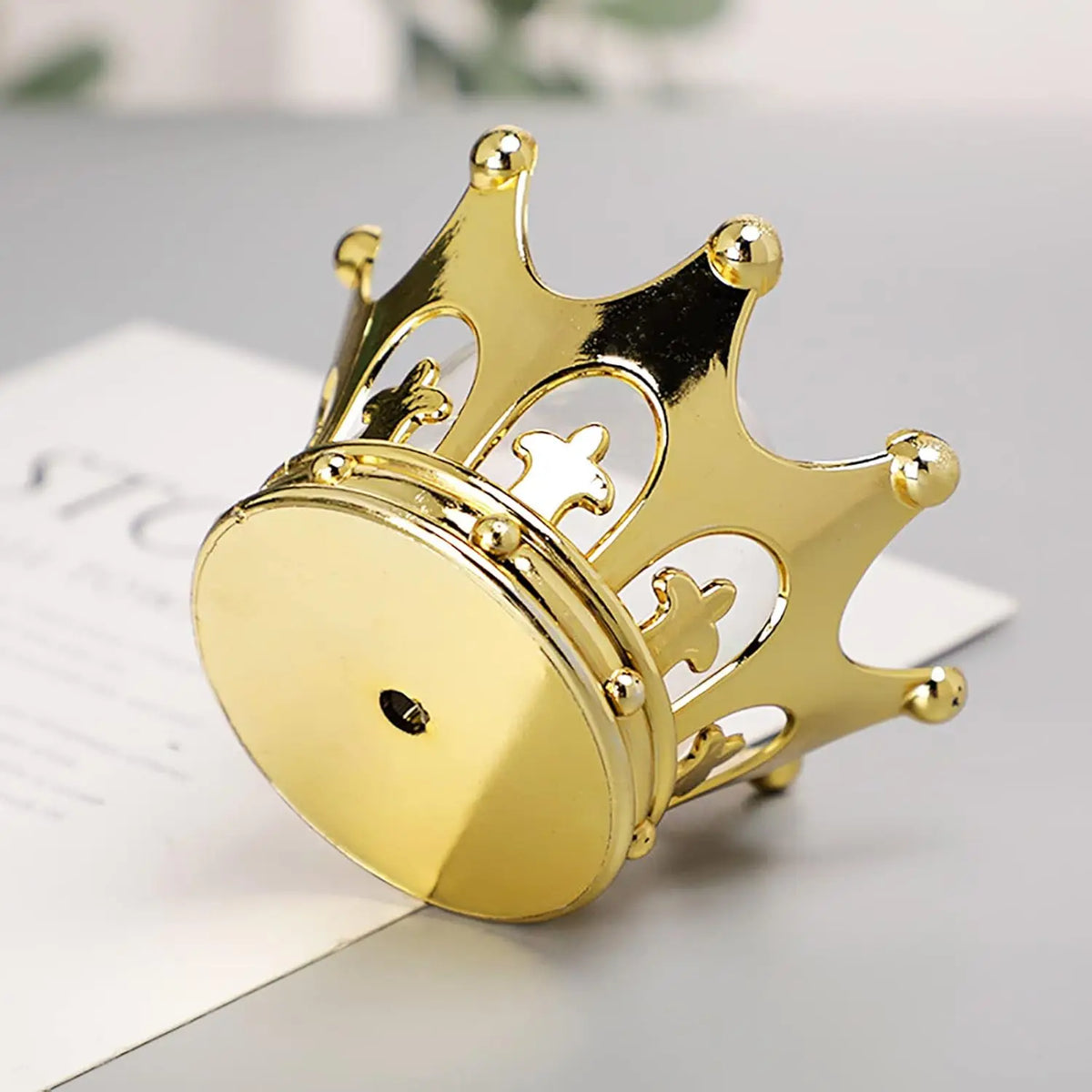 A shiny gold crown box with intricate details is shown on a white background.