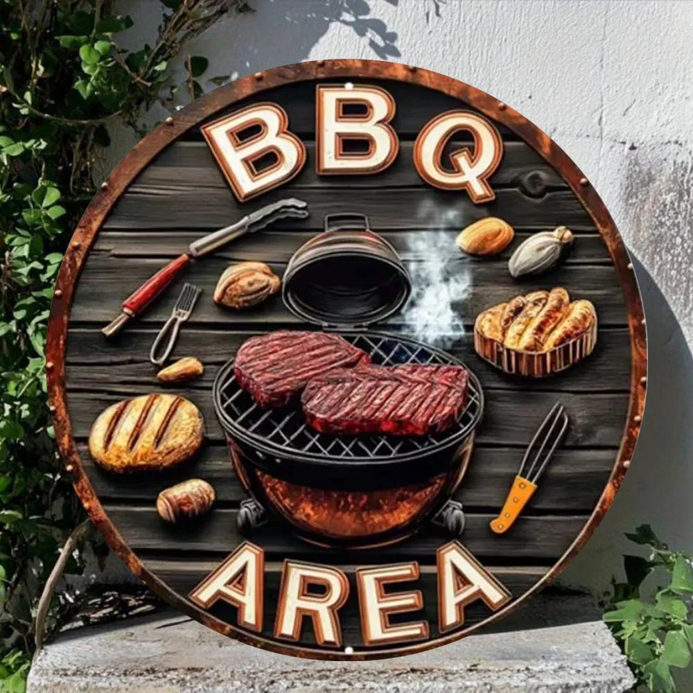 Panneau en bois rond avec les lettres BBQ AREA gravées, présentant une poêle à griller et des ustensiles.