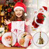 A smiling child wearing a Santa hat holds a gift wrapped in festive paper next to a hanging Santa decoration.