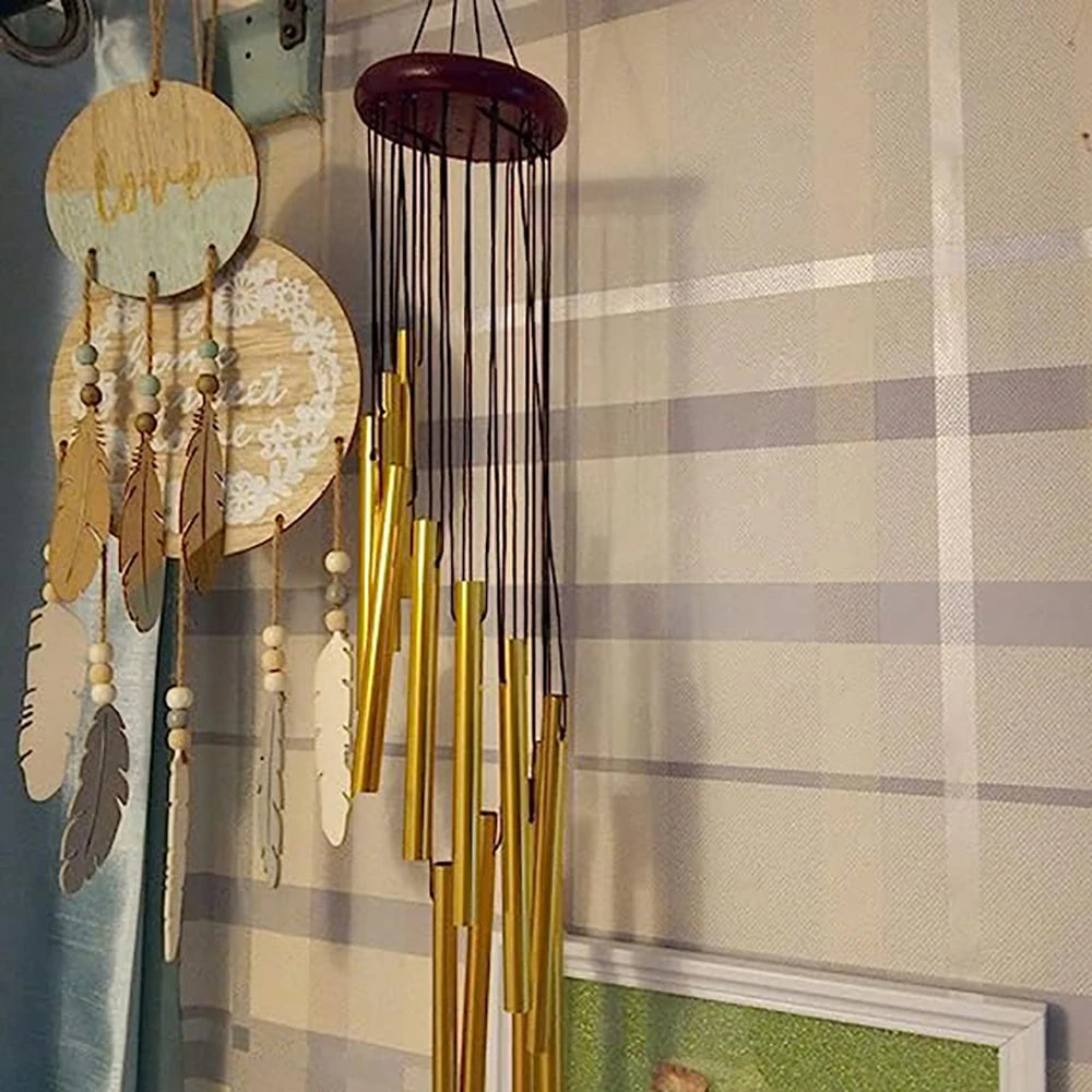 A collection of hanging wind chimes featuring wooden and metal bells in gold and silver tones against a light plaid backgroun