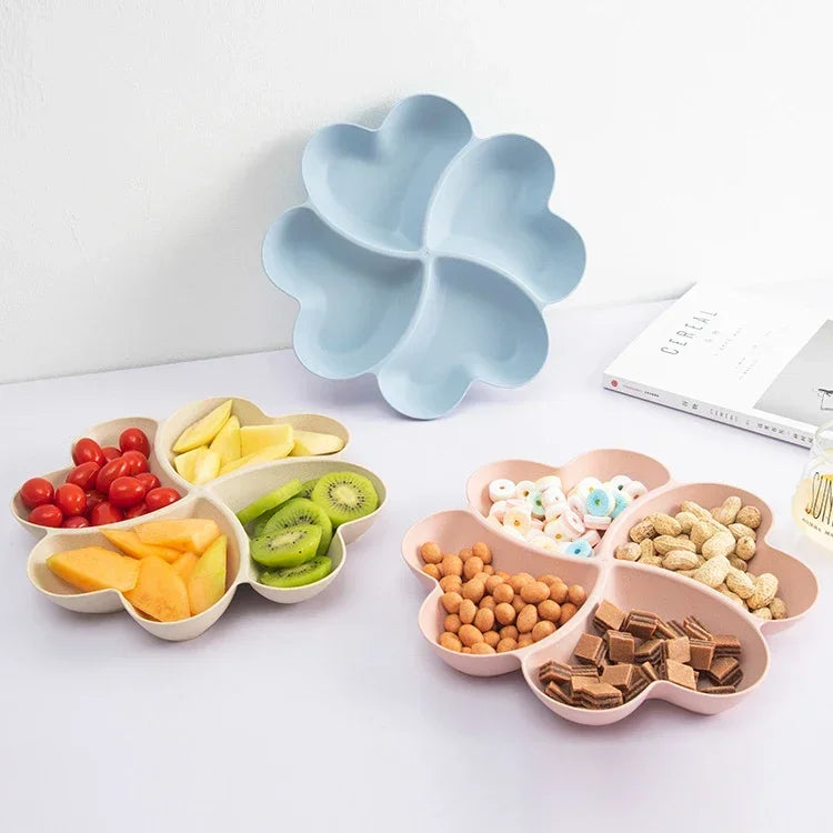 A light blue heart-shaped tray holds various dried fruits and nuts, including apples, kiwi slices, and various seeds.