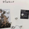 A collection of silver star-shaped decorative magnets displayed on a white background.