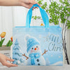 A light blue reusable non-woven Christmas gift bag featuring a cute snowman design and snowflake accents.