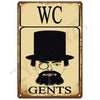 A vintage tin sign featuring the letters WC above a silhouette of a man's head and beard, with the word GENTS below.