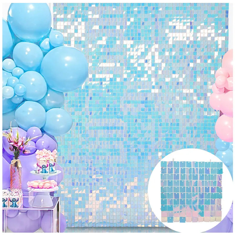 A light blue and purple glitter square wall backdrop featuring balloons and floral accents.