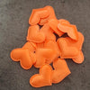 A pile of orange heart-shaped sponge confetti for weddings and celebrations.