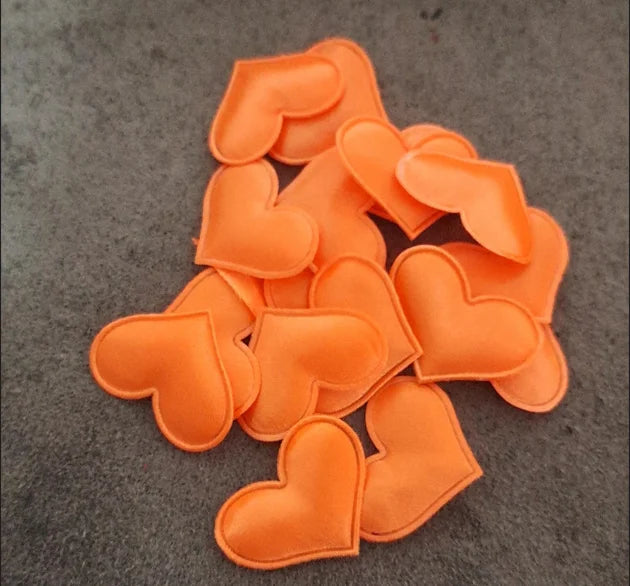 A pile of orange heart-shaped sponge confetti for weddings and celebrations.
