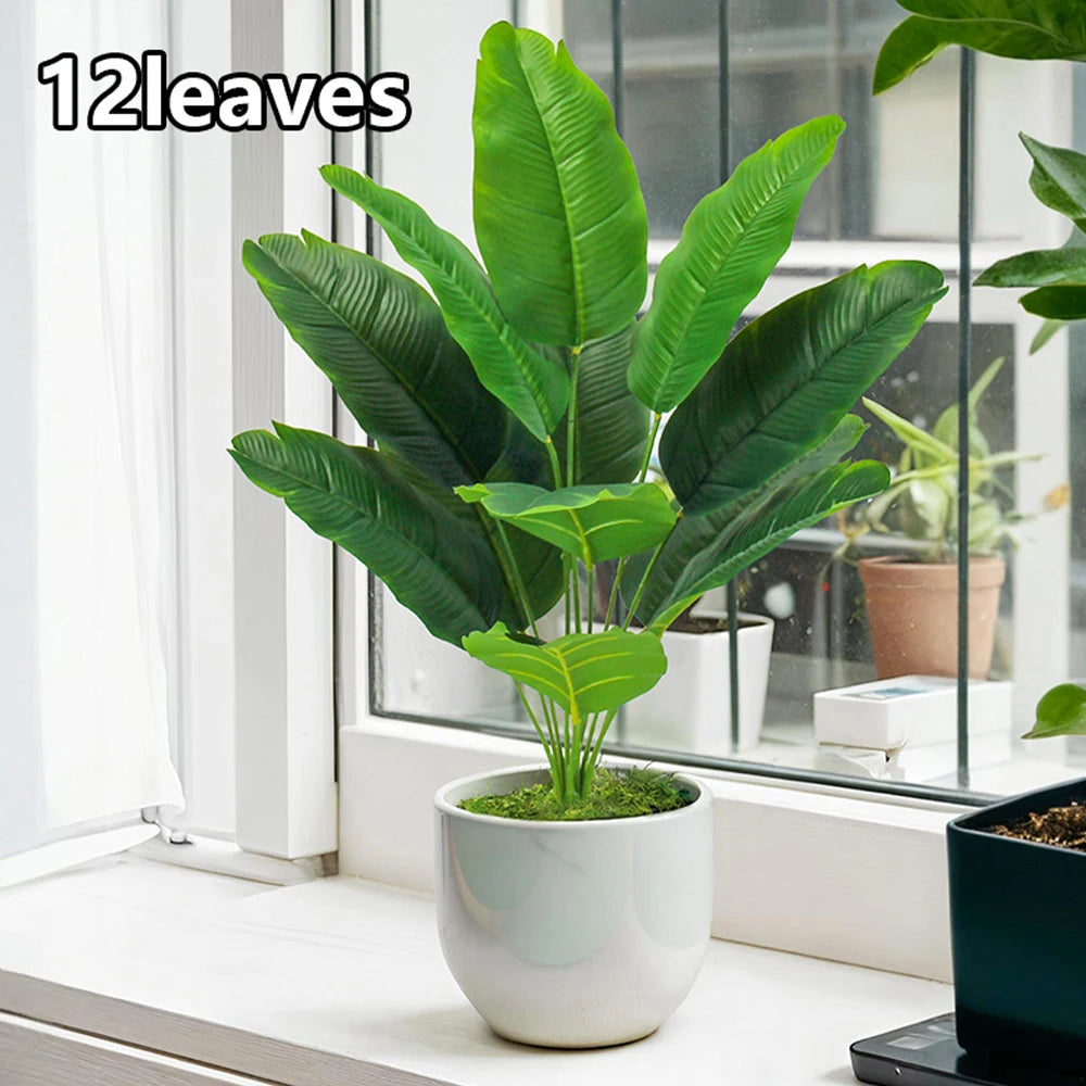 A vibrant green artificial Bird of Paradise plant in a white pot sitting on a windowsill.