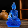 A blue resin statue of the Medicine Buddha seated on a lotus base.