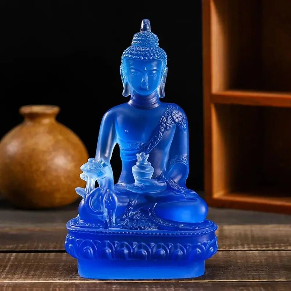 A blue resin statue of the Medicine Buddha seated on a lotus base.