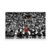 A black and white photo of a crowded basketball game featuring players and spectators.