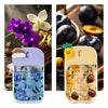 A set of four glass hand sanitizer sprays in purple, yellow, and clear glass bottles with fruit and floral accents.