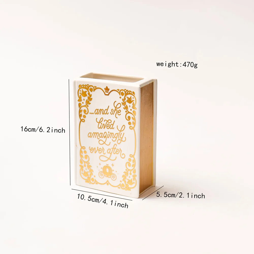 A rectangular ceramic book-shaped vase with a vintage gold finish, standing upright.